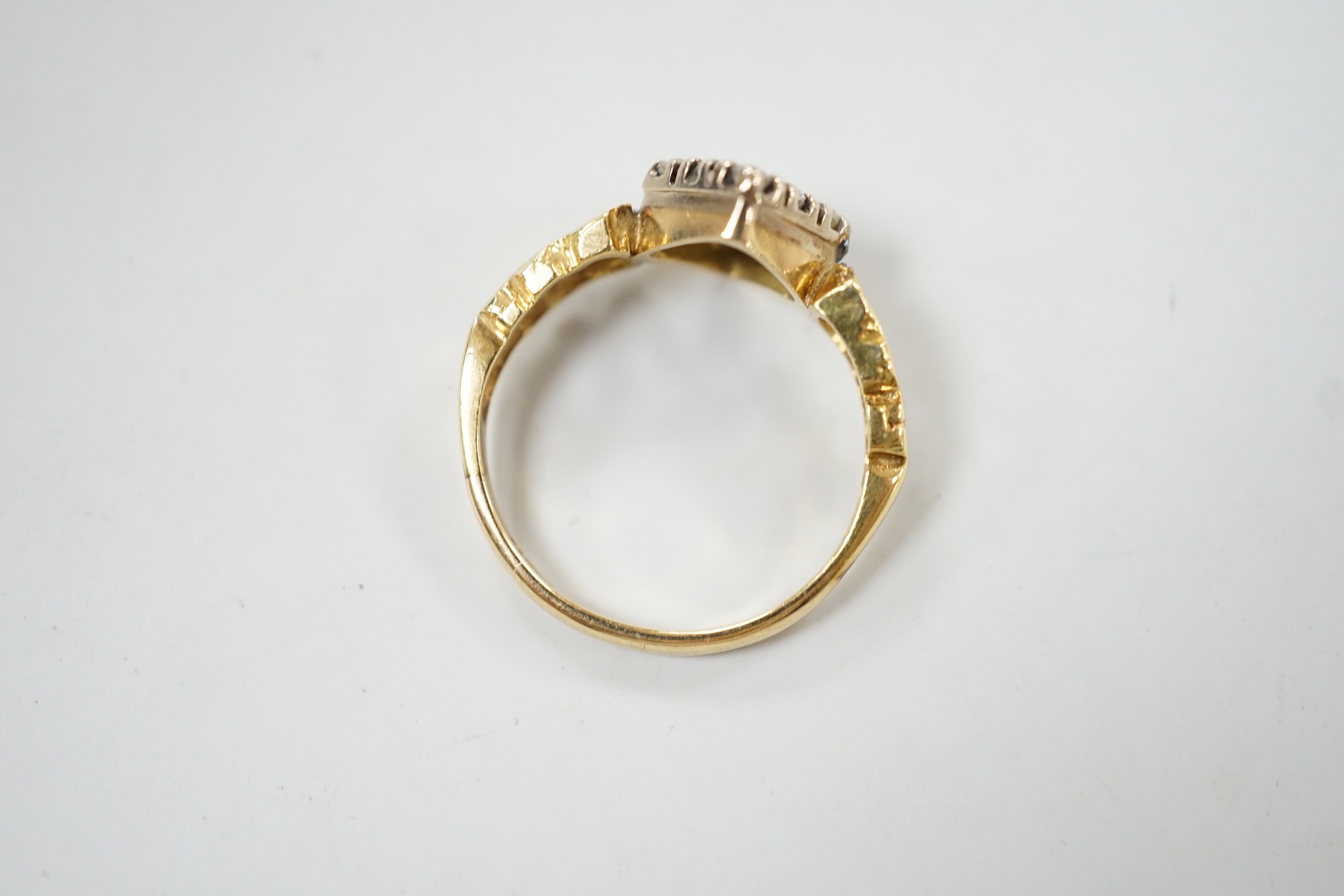 An 18ct and nine stone diamond set table ring, with pierced shoulders, size M/N, gross weight 3.7 grams.
